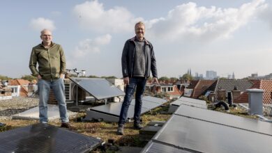energiecoaches Anne Krijger en Lars Nanninga op een groen dak met zonnepanelen