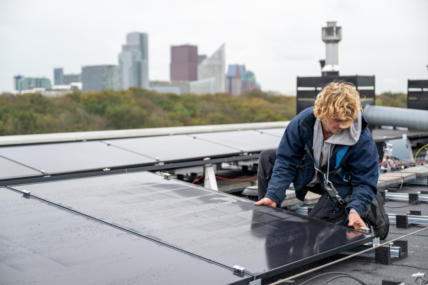 installatie van zonnepanelen op het dak van op het dak van appartementengebouw Willem Witsen